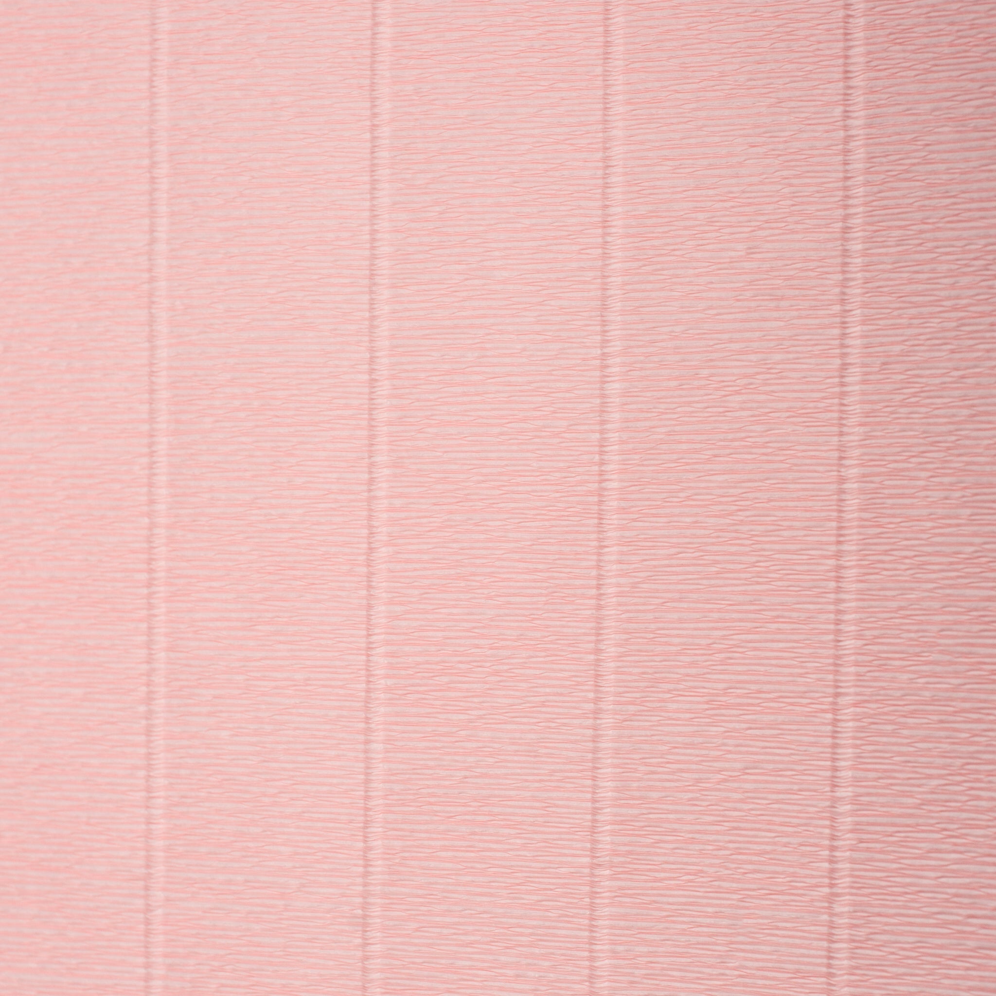 A sheet of crepe paper in camilia pink with visible texture.